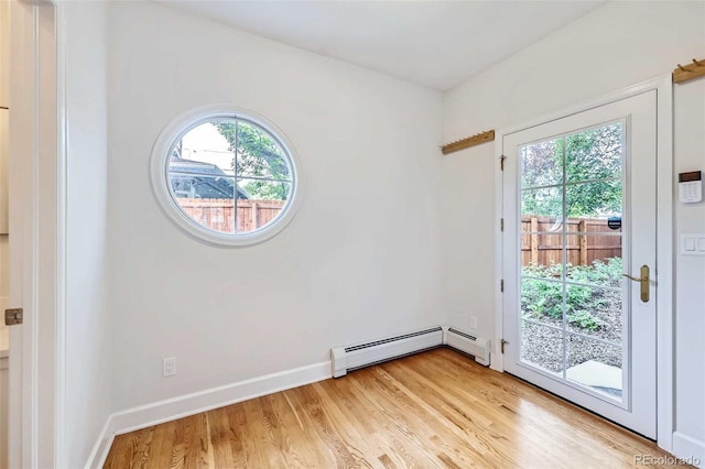 926 S Fillmore Way, Denver, CO 80209 - empty room with healthy amount of natural light, light wood-style floors, a baseboard heating unit, and baseboards
