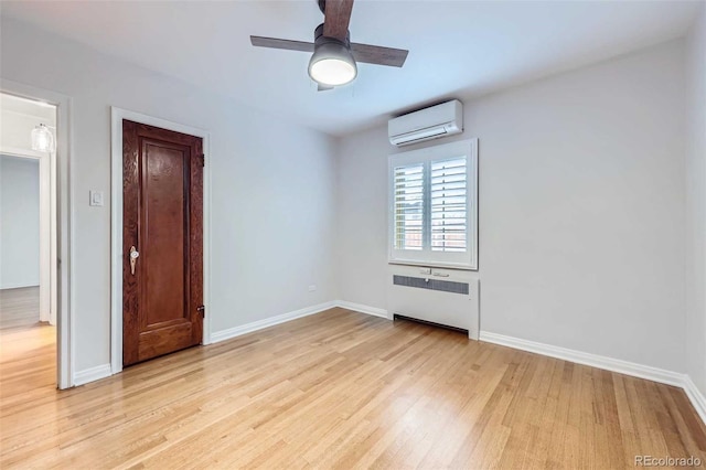 926 S Fillmore Way, Denver, CO 80209 - spare room with radiator, a wall unit AC, light wood finished floors, and baseboards