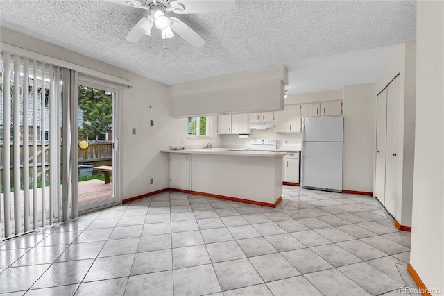 3061 W 92nd Ave Unit 8B, Westminster, CO 80031 - kitchen with freestanding refrigerator, a peninsula, stove, light countertops, and under cabinet range hood