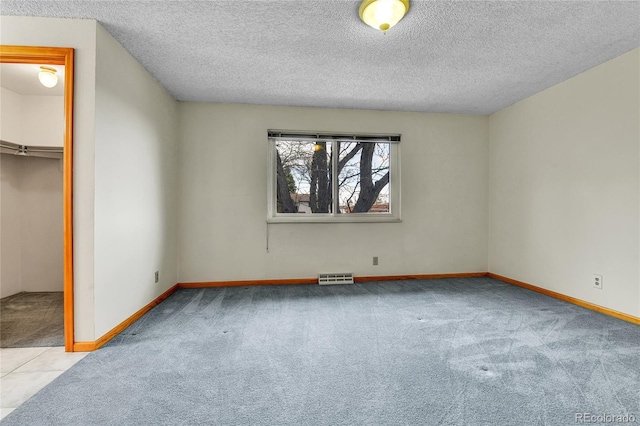 3061 W 92nd Ave Unit 8B, Westminster, CO 80031 - unfurnished bedroom with visible vents, carpet flooring, a textured ceiling, and a walk in closet