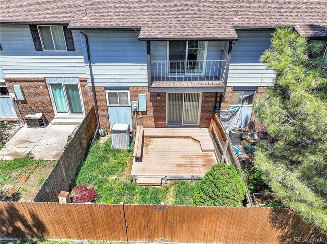 3061 W 92nd Ave Unit 8B, Westminster, CO 80031 - rear view of house featuring brick siding, a deck, a fenced backyard, and roof with shingles