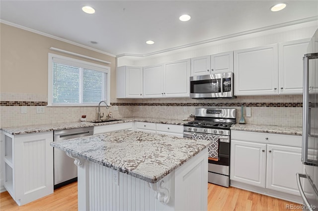 9665 Whitecliff Pl, Highlands Ranch, CO 80129 - kitchen with stainless steel appliances, a sink, white cabinetry, tasteful backsplash, and crown molding
