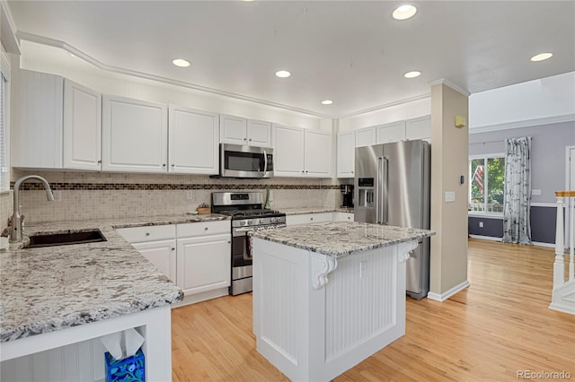 9665 Whitecliff Pl, Highlands Ranch, CO 80129 - kitchen with stainless steel appliances, a sink, backsplash, light wood-style floors, and light stone counters
