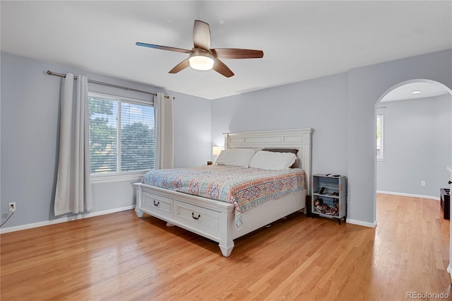 9665 Whitecliff Pl, Highlands Ranch, CO 80129 - bedroom with arched walkways, light wood-style flooring, baseboards, and a ceiling fan