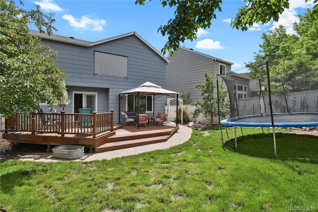 9665 Whitecliff Pl, Highlands Ranch, CO 80129 - back of property with a trampoline, a gazebo, a lawn, and a wooden deck