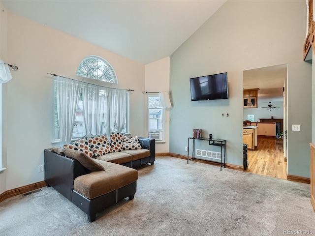 carpeted living room with high vaulted ceiling and ceiling fan