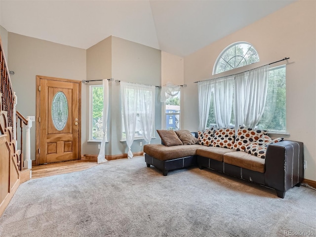 living room featuring high vaulted ceiling and carpet flooring