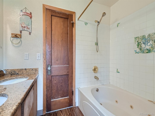 bathroom with double vanity, hardwood / wood-style flooring, and tiled shower / bath combo