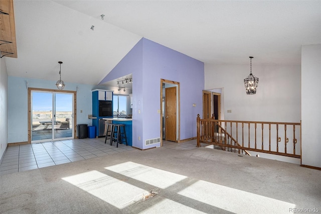 unfurnished living room with light carpet and high vaulted ceiling