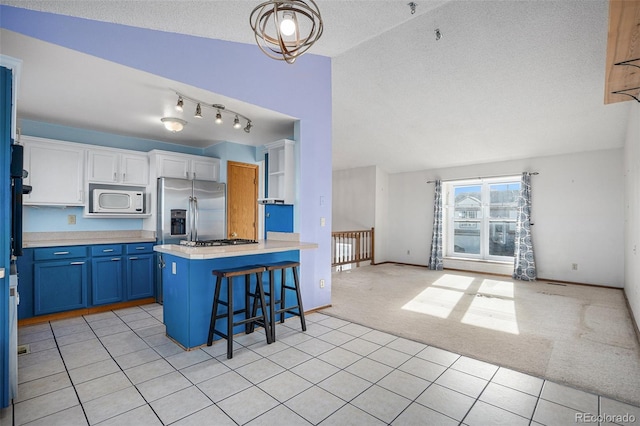 kitchen featuring stainless steel refrigerator with ice dispenser, a kitchen breakfast bar, white microwave, light colored carpet, and white cabinets