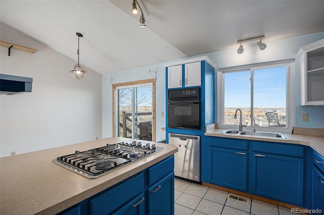 kitchen featuring a textured ceiling, stainless steel appliances, vaulted ceiling, blue cabinets, and sink