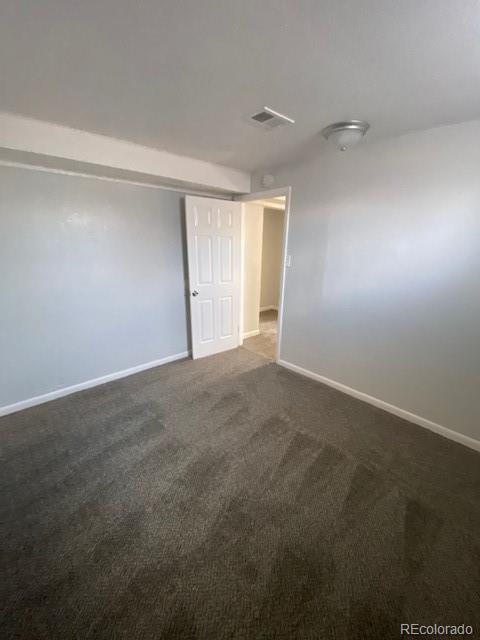 spare room with dark carpet