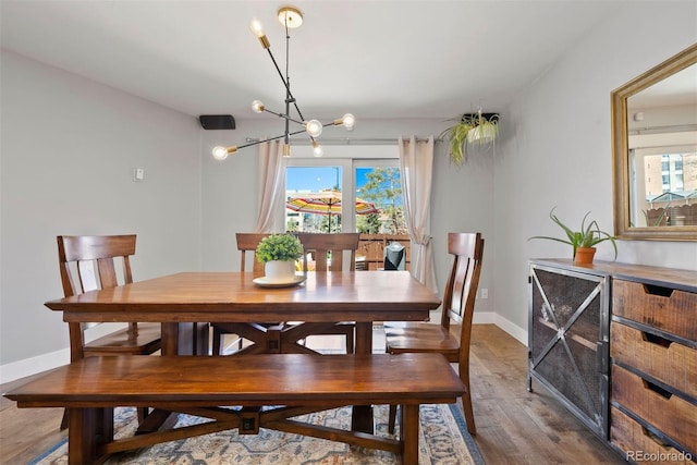 dining room with wood finished floors, a wealth of natural light, and baseboards