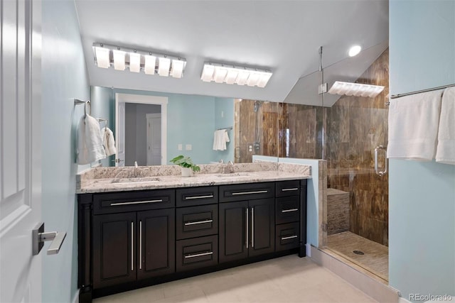 bathroom featuring a stall shower, a sink, and double vanity