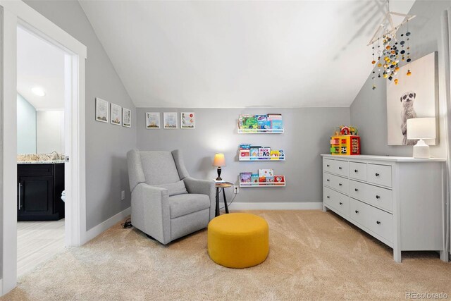 living area featuring light carpet, lofted ceiling, and baseboards