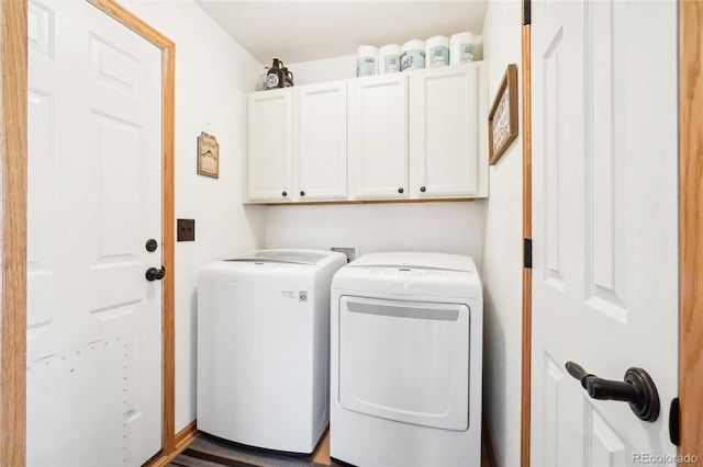 clothes washing area with cabinets and independent washer and dryer