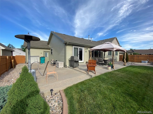 back of property with a gazebo, a patio, and a lawn