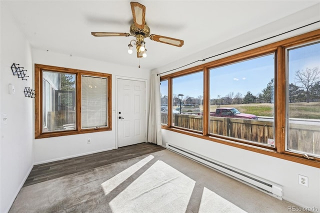 unfurnished sunroom featuring a wealth of natural light and a baseboard heating unit