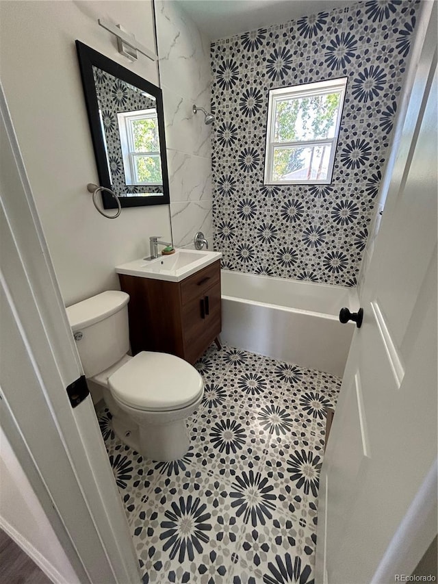 full bathroom with tiled shower / bath combo, vanity, a wealth of natural light, and toilet