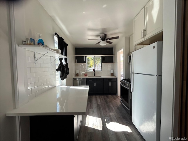 kitchen with appliances with stainless steel finishes, kitchen peninsula, sink, and decorative backsplash