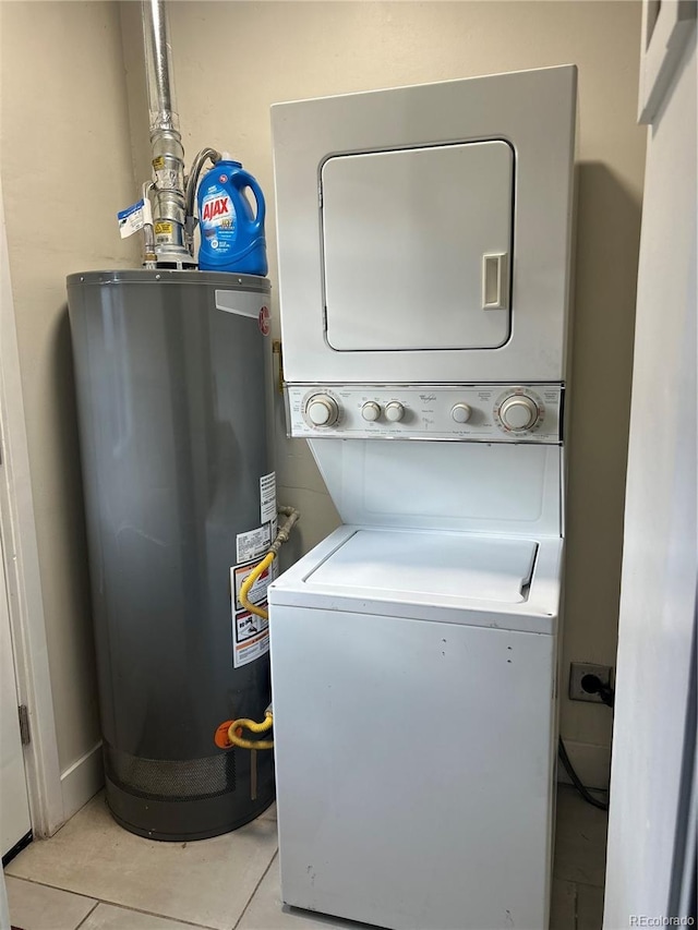 laundry area featuring water heater, light tile patterned floors, and stacked washer and clothes dryer