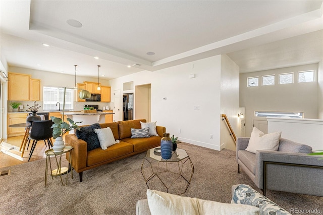 carpeted living room featuring sink