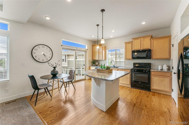 kitchen with black appliances, light hardwood / wood-style flooring, and a wealth of natural light