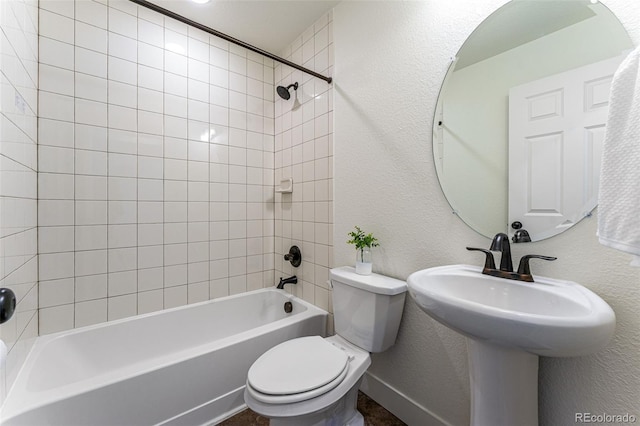 bathroom featuring tiled shower / bath combo and toilet