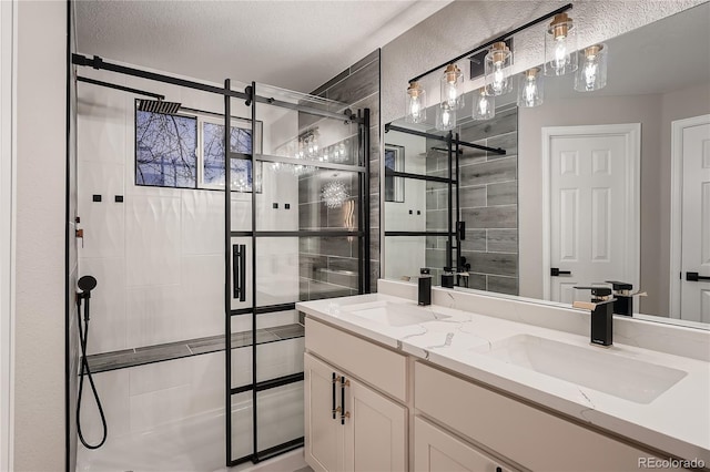 bathroom with vanity, an enclosed shower, and a textured ceiling