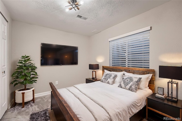 bedroom featuring carpet and a textured ceiling