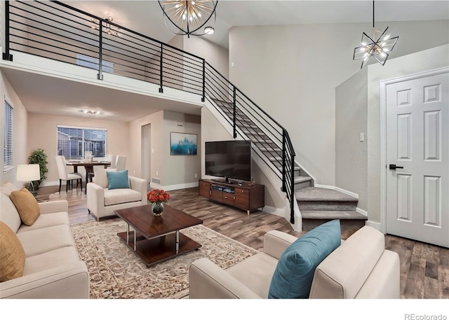 living room featuring hardwood / wood-style flooring, a chandelier, and a high ceiling