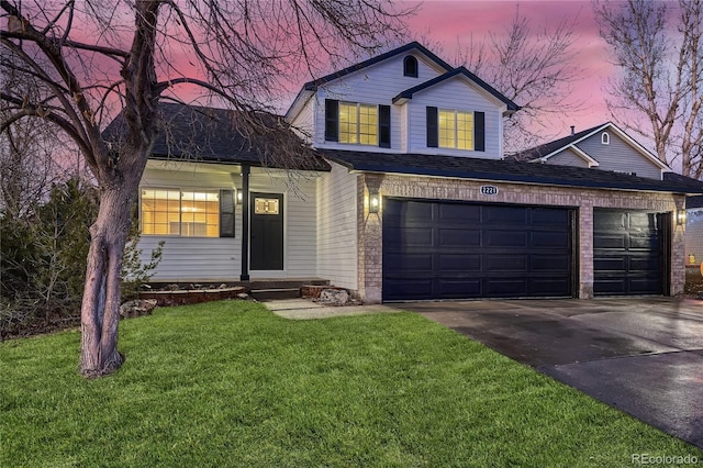 view of front of home with a garage and a lawn