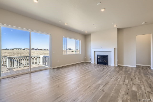 unfurnished living room with a fireplace and light wood-type flooring