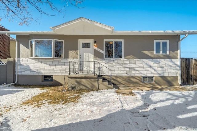 view of front of property with stone siding and fence