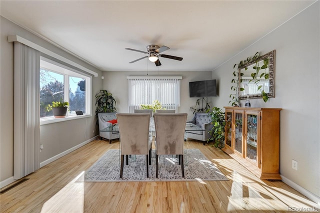 dining space featuring ceiling fan, baseboards, and wood finished floors