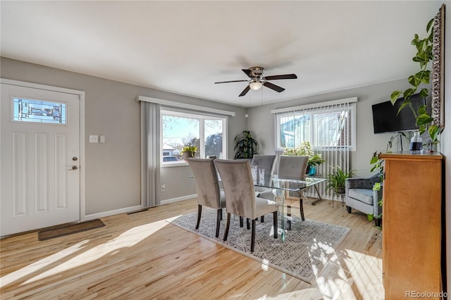 dining space featuring a ceiling fan, wood finished floors, visible vents, and baseboards