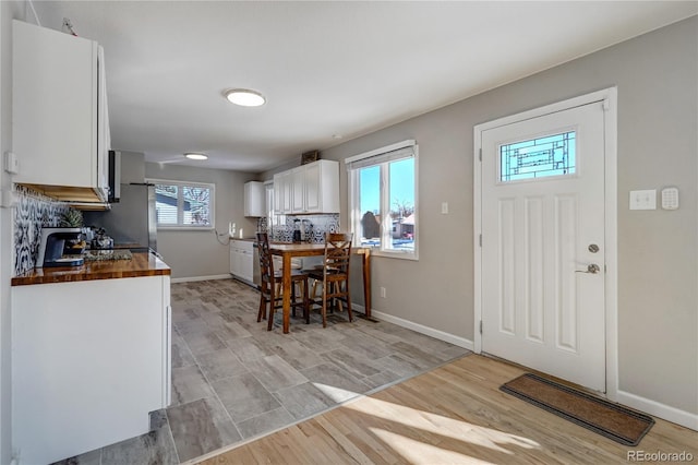 foyer with light wood finished floors and baseboards