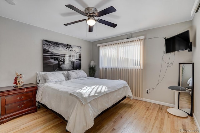 bedroom featuring a ceiling fan, light wood-style flooring, and baseboards