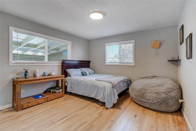 bedroom with baseboards and wood finished floors