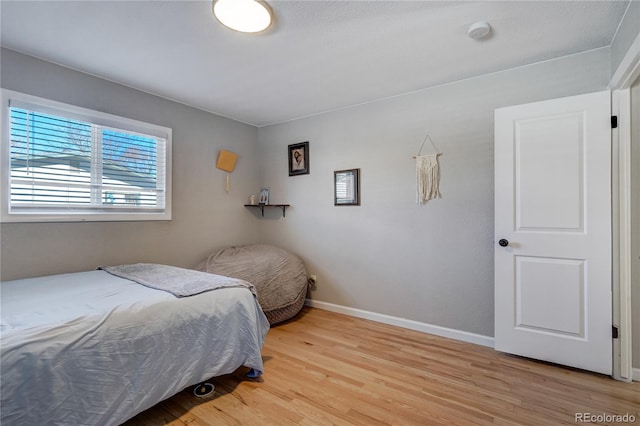 bedroom with baseboards and wood finished floors