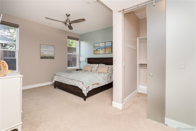 carpeted bedroom with ceiling fan and a spacious closet