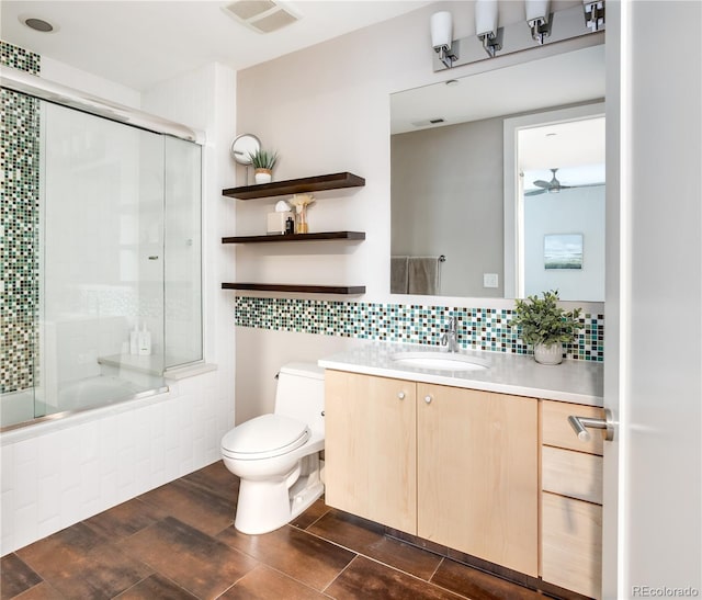 full bathroom with vanity, tasteful backsplash, toilet, hardwood / wood-style flooring, and enclosed tub / shower combo