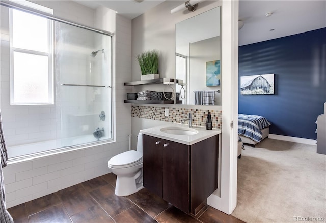 full bathroom with shower / bath combination with glass door, vanity, hardwood / wood-style floors, tasteful backsplash, and toilet