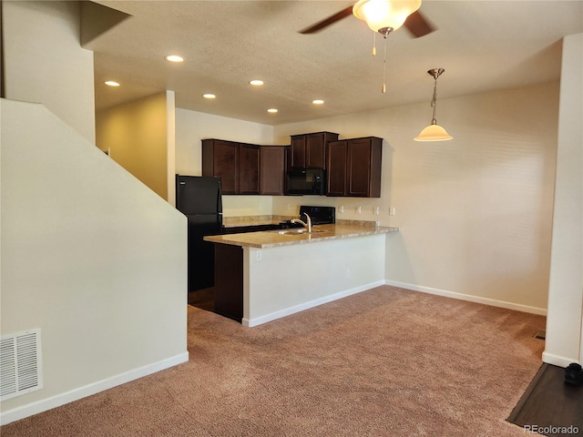 kitchen with visible vents, hanging light fixtures, a peninsula, black appliances, and a sink