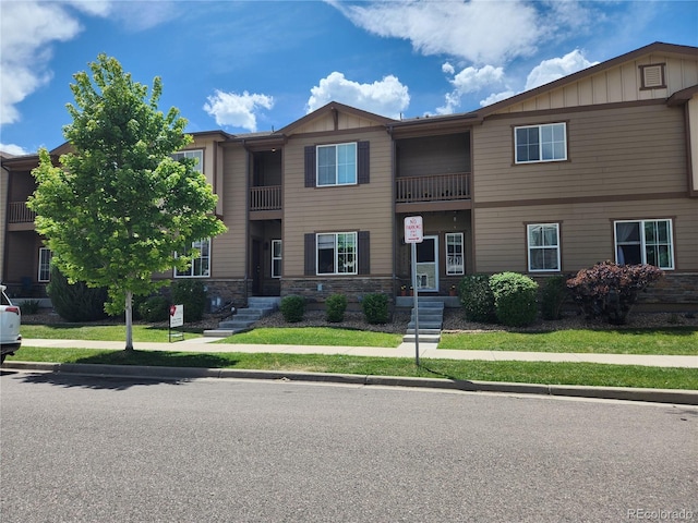 1211 Bistre St, Longmont, CO 80501 - townhome / multi-family property with stone siding, board and batten siding, and a front lawn