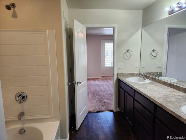 1211 Bistre St, Longmont, CO 80501 - bathroom featuring double vanity, wood finished floors, tub / shower combination, and baseboards