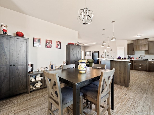 dining room featuring wood tiled floor and a notable chandelier