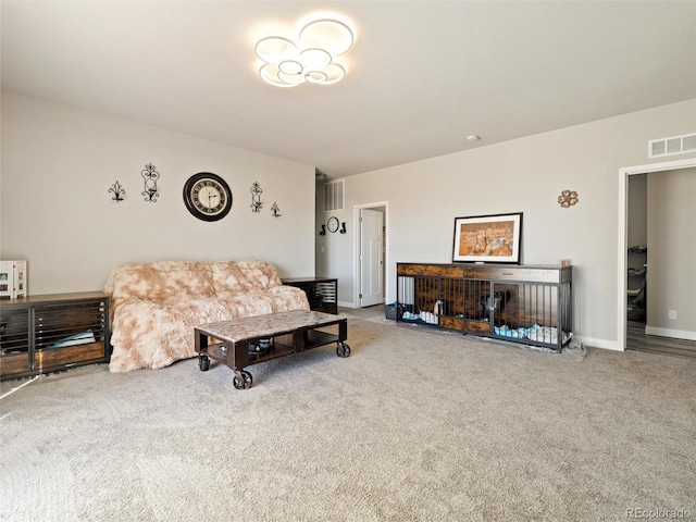 carpeted living area featuring visible vents and baseboards