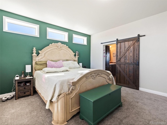 bedroom with carpet floors, baseboards, and a barn door