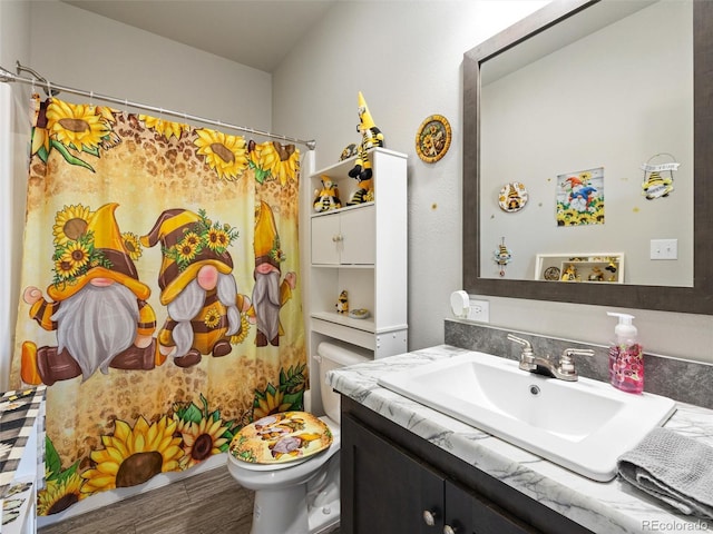 bathroom with a shower with curtain, vanity, toilet, and wood finished floors